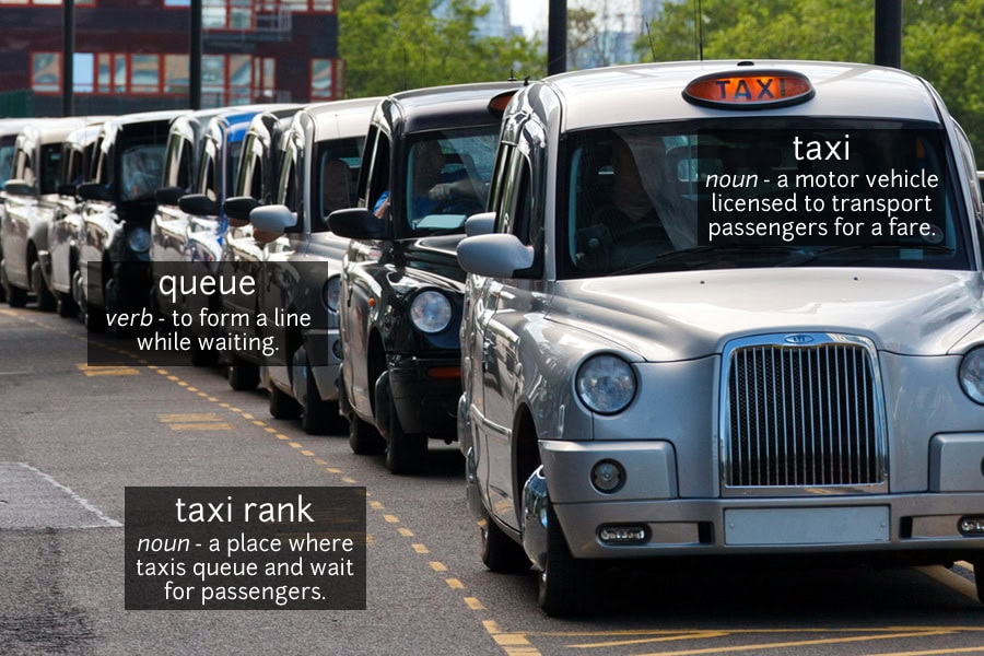 Photo vocabulary: a long line of London taxis, a silver one at the front, waiting at a taxi rank, labelled taxi, queue and taxi rank.